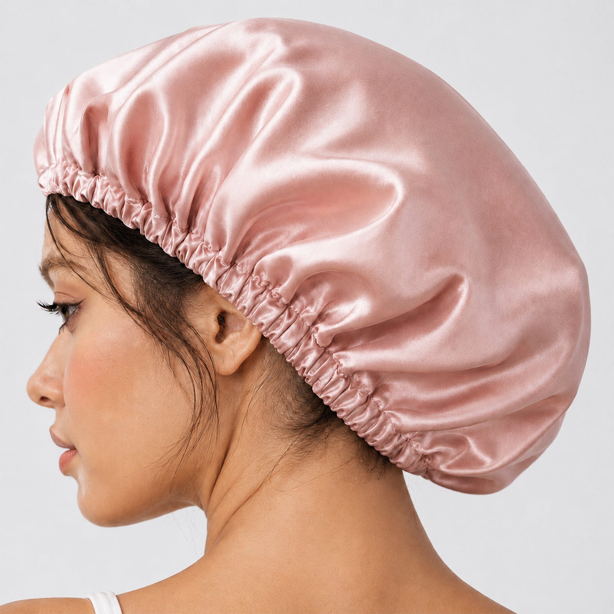 Side profile of a woman wearing a pink Silk Bonnet with her hair fully tucked in